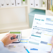Man calculating electric bill statement and home energy consumption