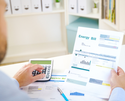 Man calculating electric bill statement and home energy consumption