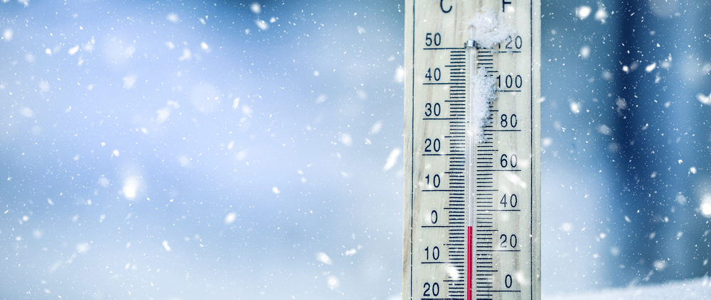 Thermometer on snow shows low temperatures in celsius or farenheit