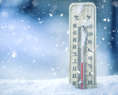 Thermometer on snow shows low temperatures in celsius or farenheit